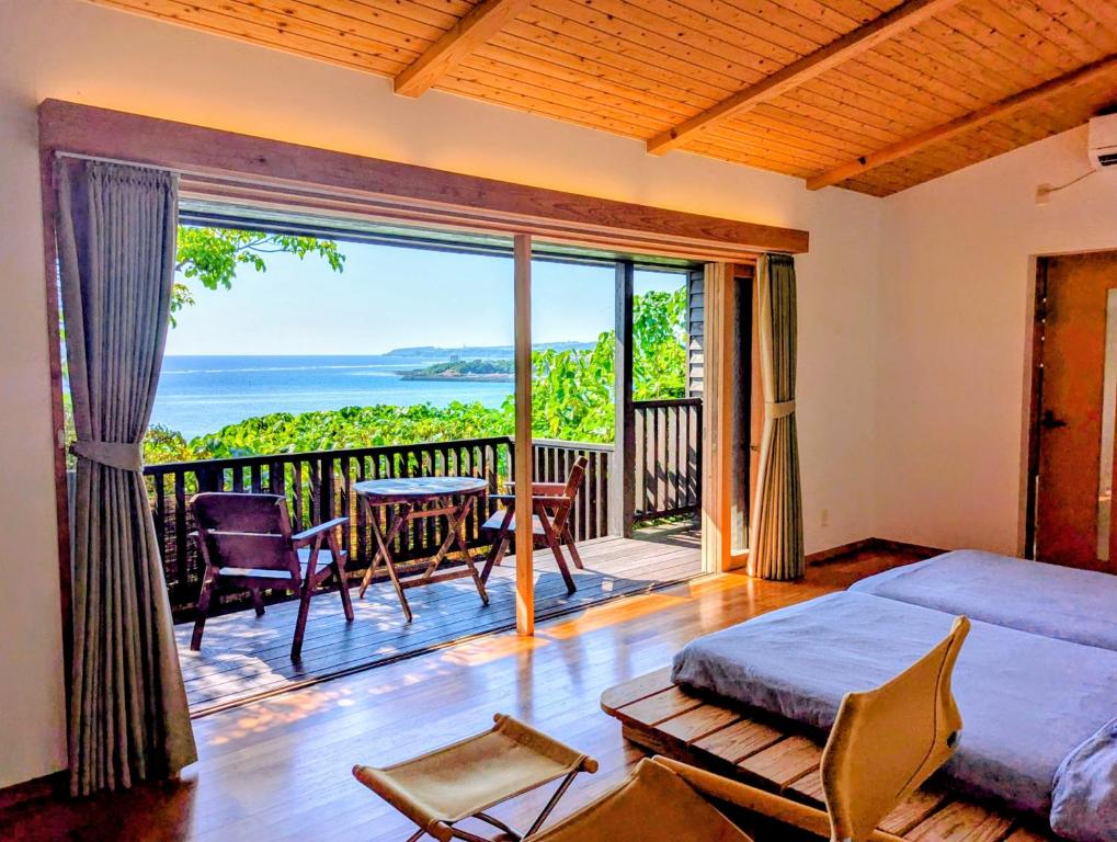 南城市にあるVilla SACHIIBARU 浜辺の茶屋 の 宿のベッドルーム1室(ベッド1台付)、景色を望むバルコニーが備わります。