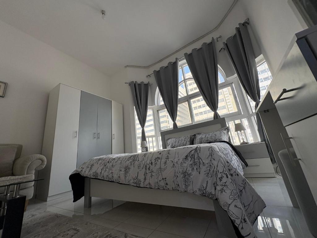 a bedroom with a bed and a large window at Lang Homes in Abu Dhabi