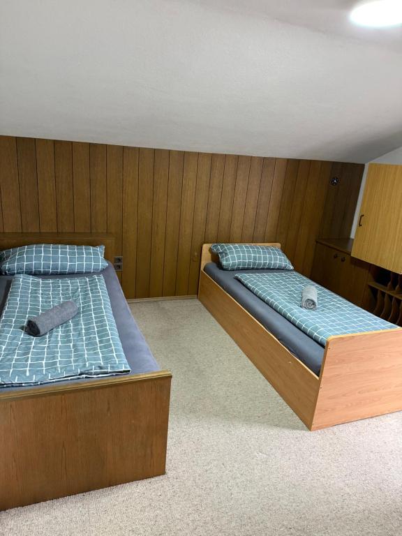 a bedroom with two beds with blue sheets at OH 4 in Dornbirn