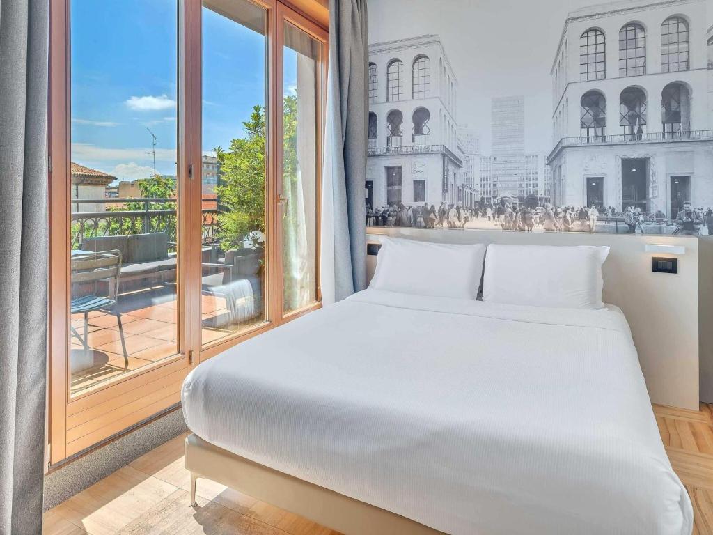 a bed in a room with a large window at B&B Hotel Milano Sant'Ambrogio in Milan
