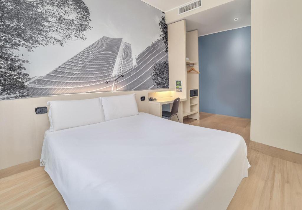 a bedroom with a white bed and a picture of buildings at B&B Hotel Milano Cenisio Garibaldi in Milan