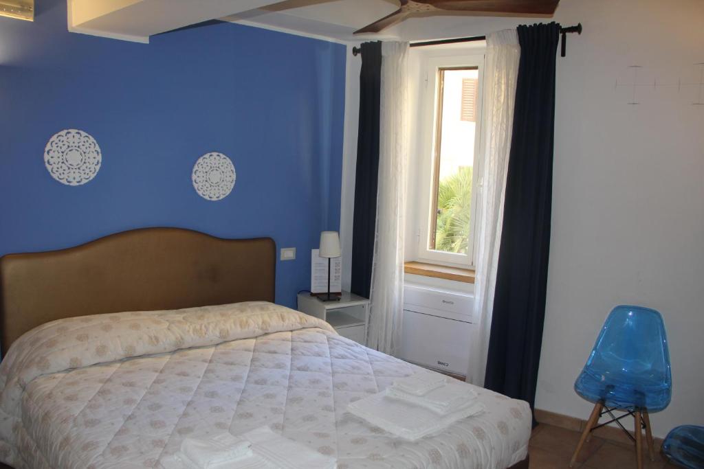 a blue bedroom with a bed and a window at Porta Mazzini Affittacamere in Iesi