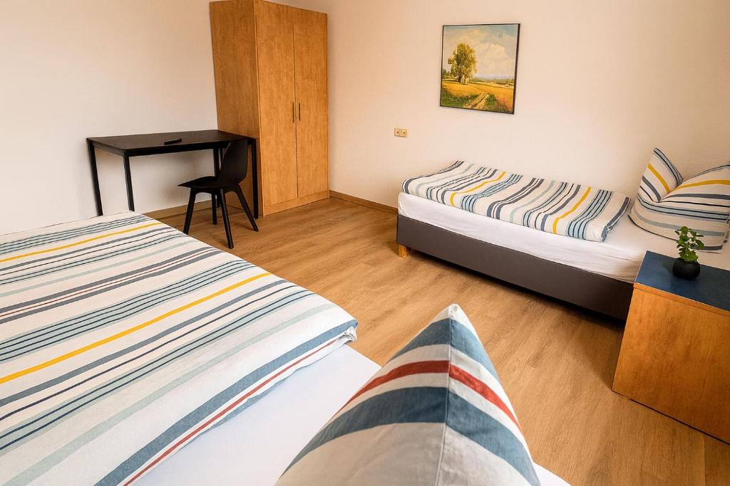 una camera d'albergo con due letti e una scrivania di Apartment für Monteure in Merseburg a Merseburg