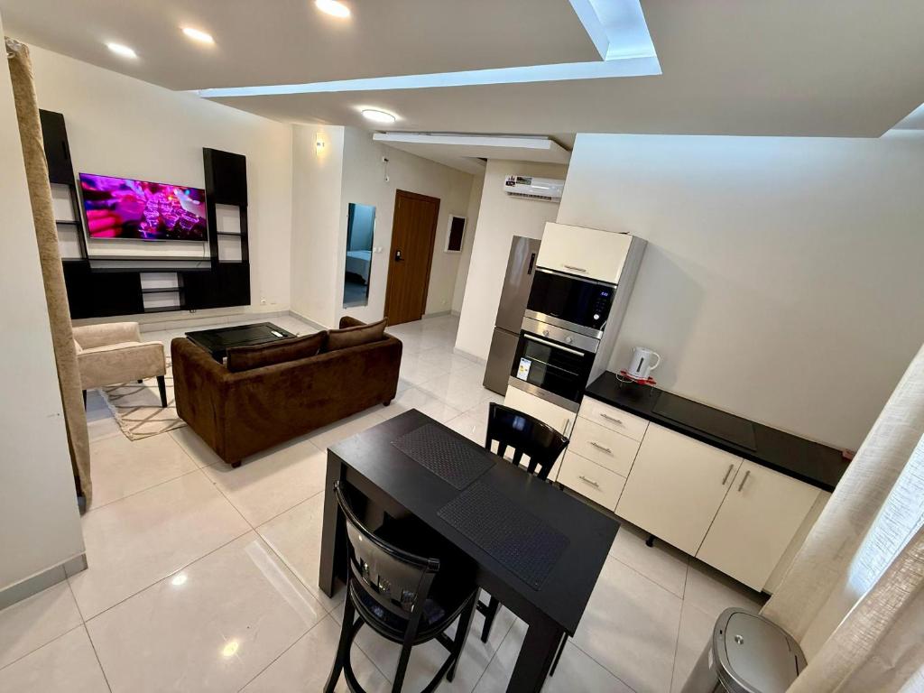 a kitchen and living room with a table and a couch at Appart'Hotels TEK & TEY in Dakar