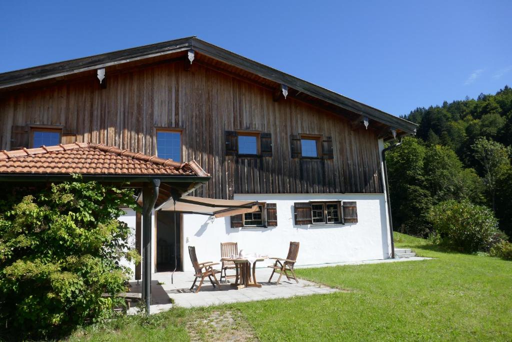 a house with a table and chairs in front of it at Bodenschneidsuiten Das Gschwandler in Tegernsee