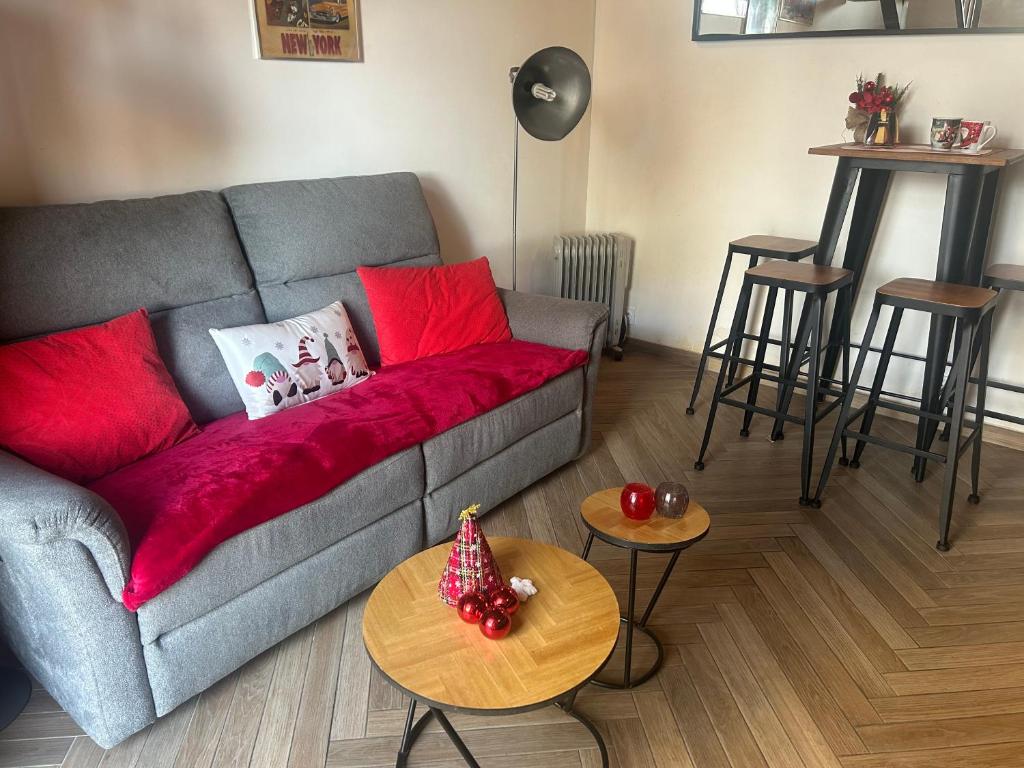 Una sala de estar con un sofá con almohadas rojas y mesas. en Ideal location triplex centre-ville Bastia, en Bastia