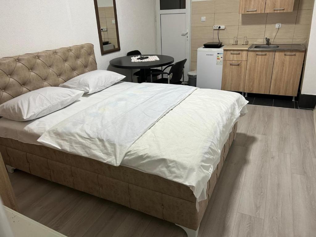 Una cama grande en una habitación con cocina. en Apartmani BALKAN, en Sjenica