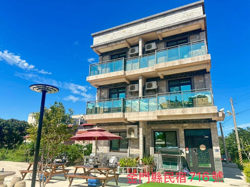 ein Gebäude mit Tischen und Stühlen davor in der Unterkunft 五星佶民宿 in Jinning