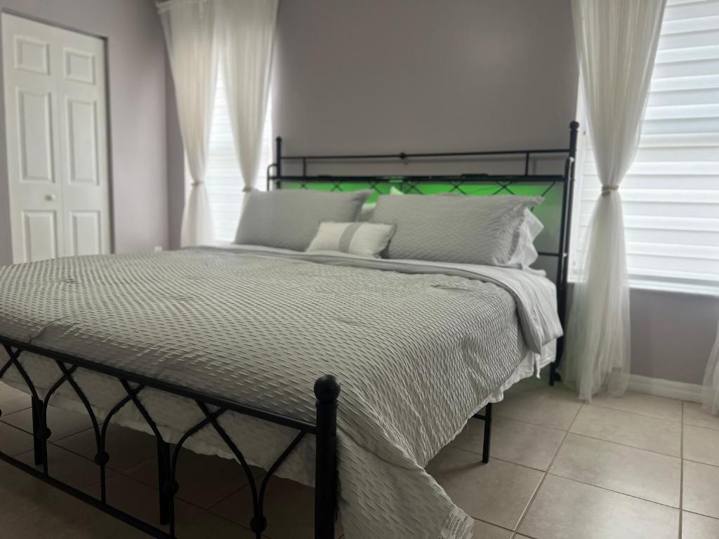 una camera da letto con un letto grande con testiera verde di Vacation QJR a Cutler Bay