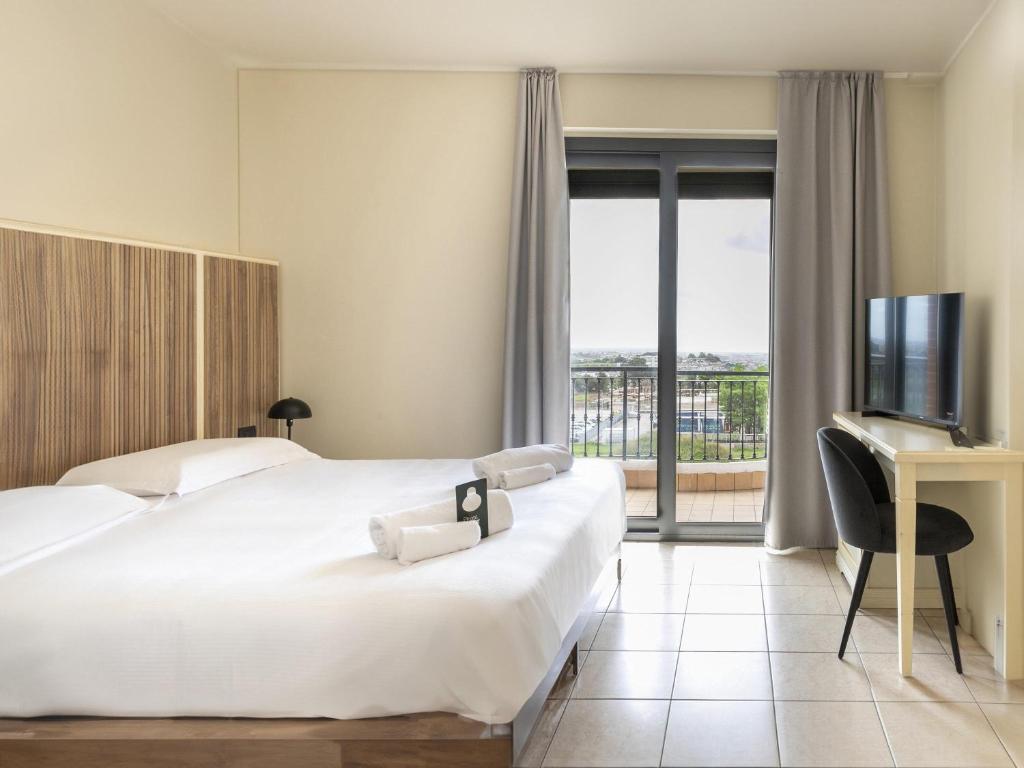 Ένα ή περισσότερα κρεβάτια σε δωμάτιο στο B&B HOTEL Pomezia Cortese