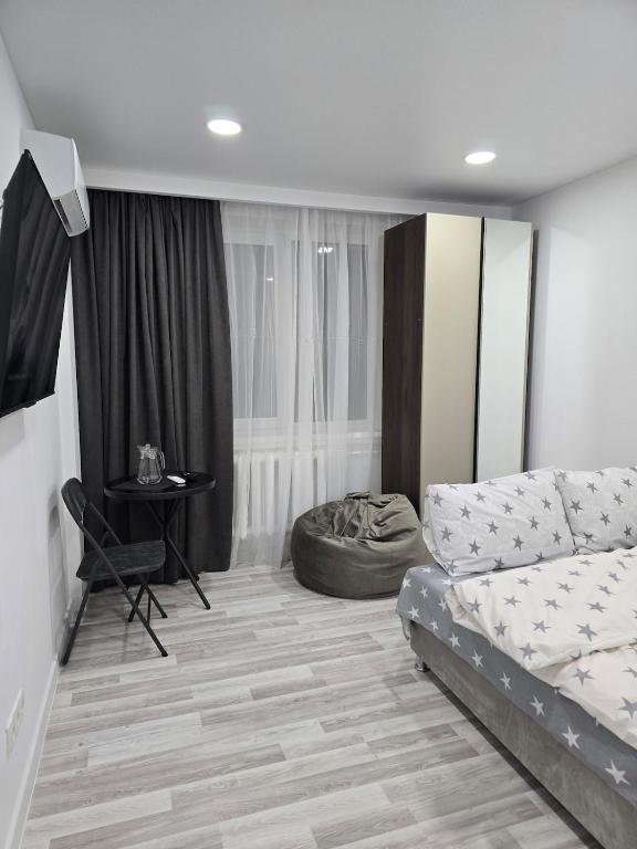 a living room with a bed and a table at Studio modern 10 min de centru, perfect pentru doi in Chişinău