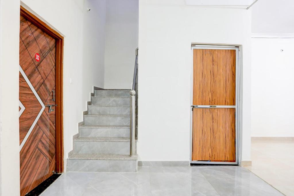 a stairway with a wooden door and stairs at Hotel O Ayushman in Jabalpur