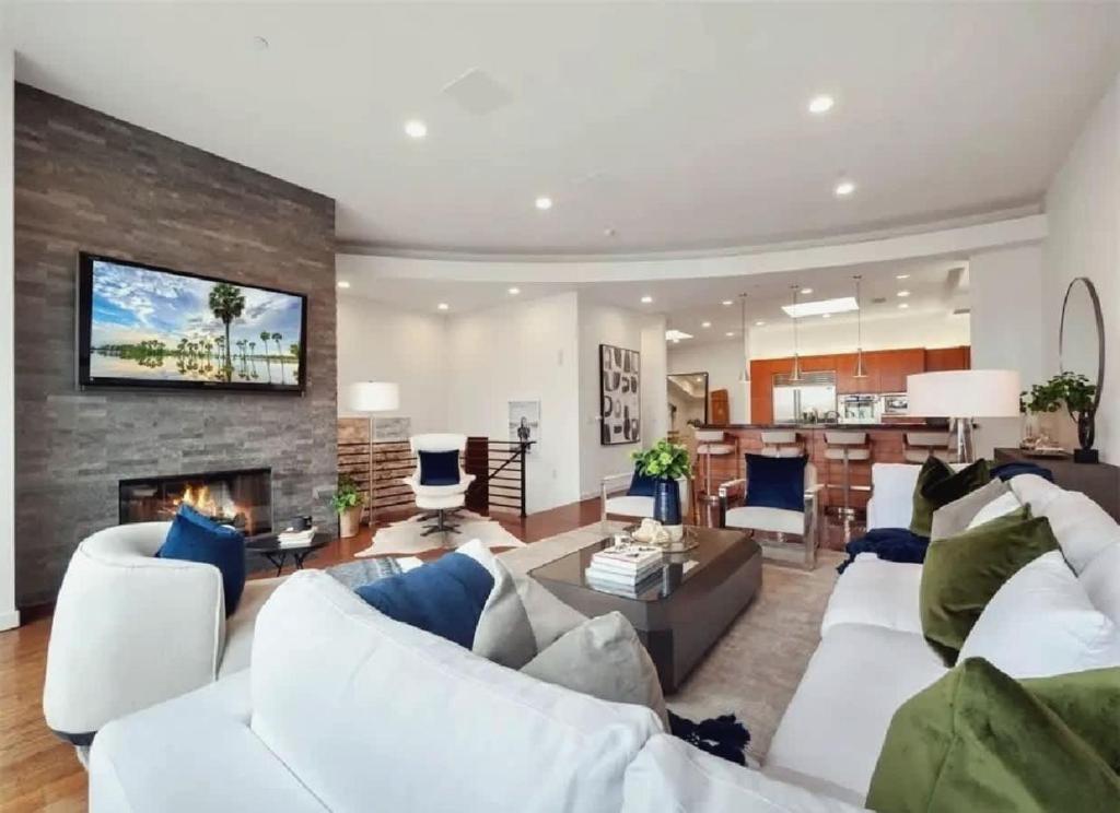 Una sala de estar con muebles blancos y chimenea. en Elegant Three-Bedroom Beachfront Home With Wide Ocean Views, en Redondo Beach