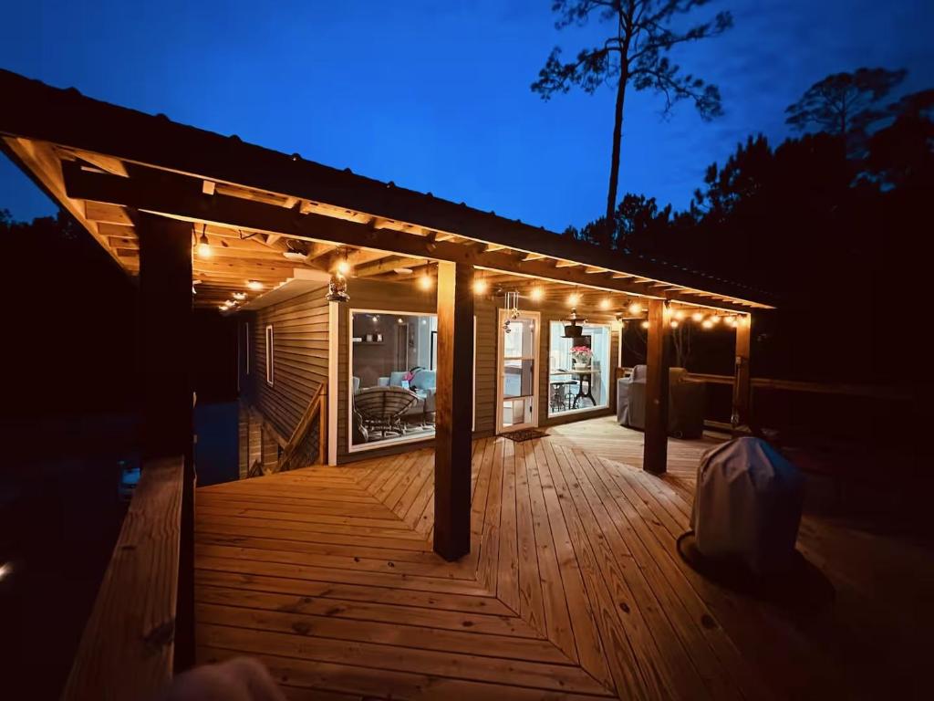 ein Holzdeck mit Lichtern in der Nacht in der Unterkunft Luxury Waterfront property in Bay Saint Louis
