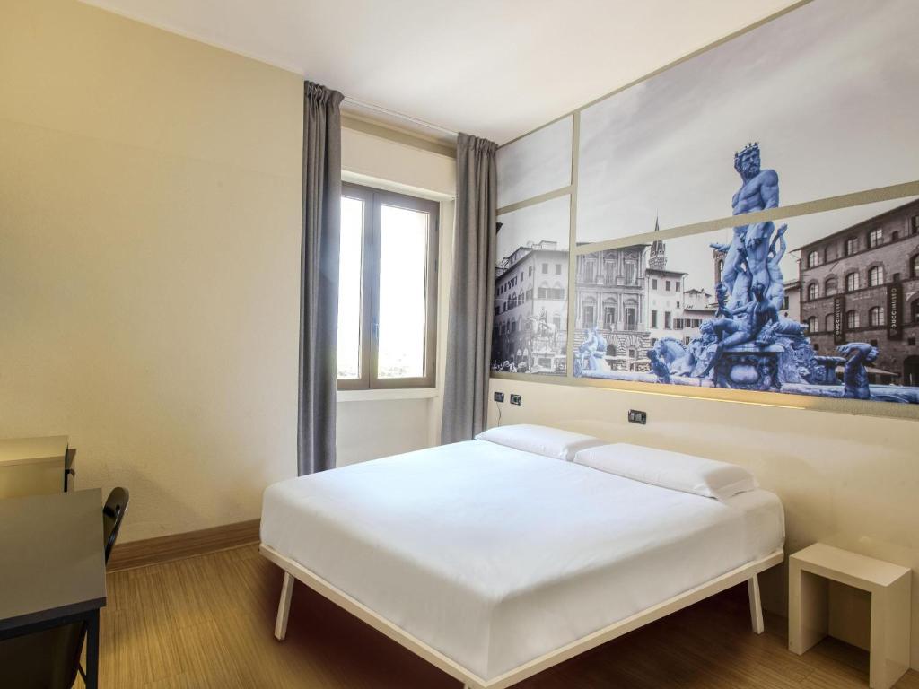 ein Schlafzimmer mit einem weißen Bett und einem Gemälde an der Wand in der Unterkunft B&B Hotel Firenze Novoli in Florenz