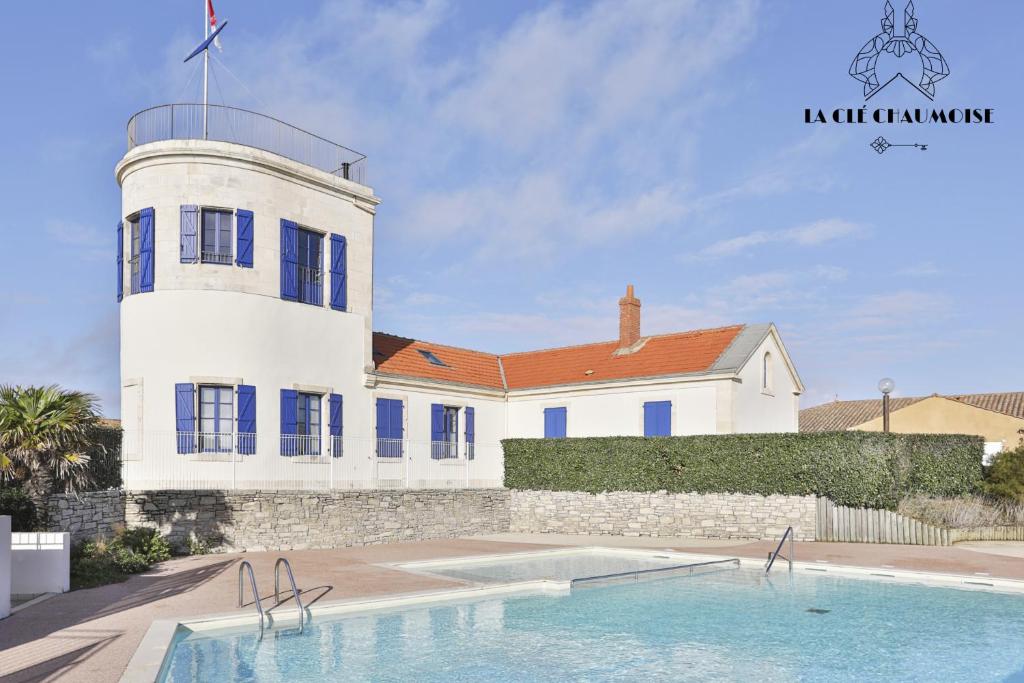 een huis met een zwembad voor een vuurtoren bij Vivez dans cet ancien semaphore avec vue mer in Les Sables-dʼOlonne