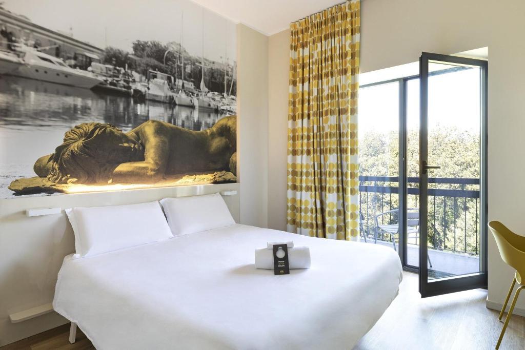 Un dormitorio con una cama blanca y un cuadro en la pared. en B&B Hotel Savona, en Savona