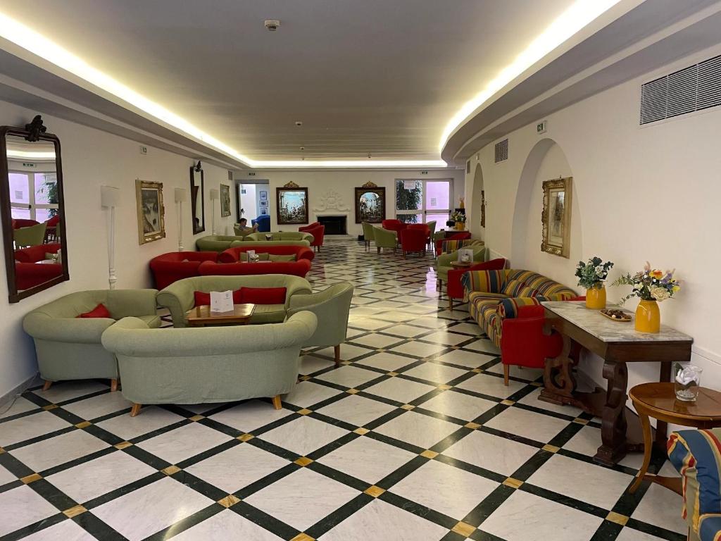 een lobby met banken, stoelen en tafels bij Hotel Villa Maria in Sorrento
