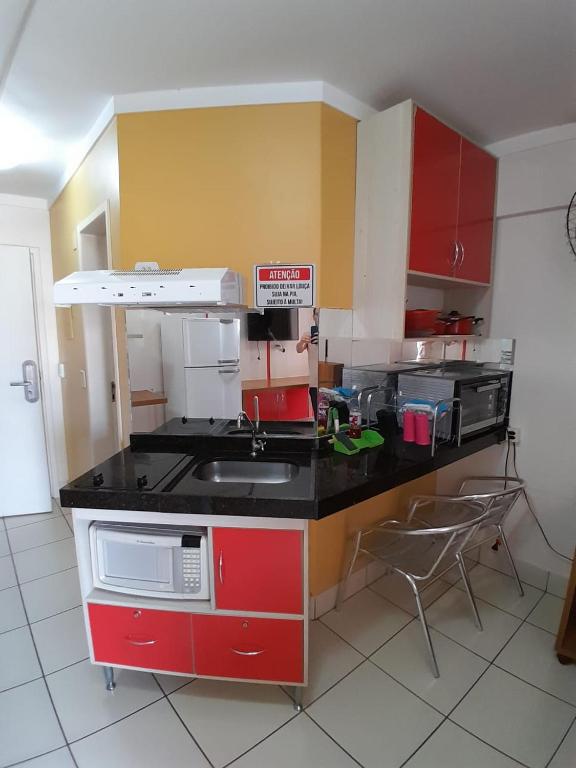 a kitchen with red and yellow cabinets and a sink at residencial diroma exclusive in Caldas Novas