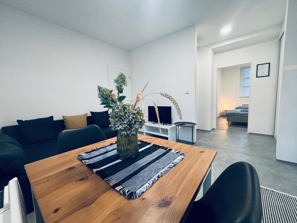 a living room with a wooden table and a couch at Apartmány Atrium in Litoměřice