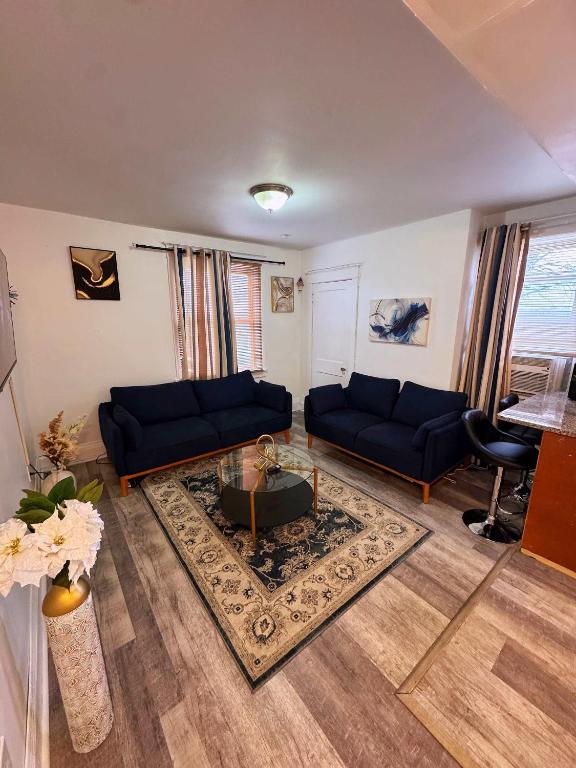 un soggiorno con divani blu e un tavolo di Natvy Alpha Suite - 3 Bedroom a Munhall