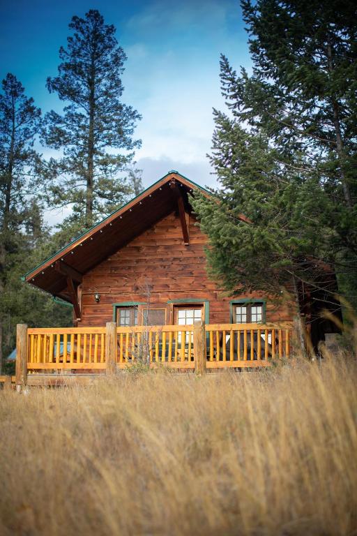 a log cabin with a fence in front of it at Radium Cabins Centrally located in Radium Hot Springs BC in Radium Hot Springs