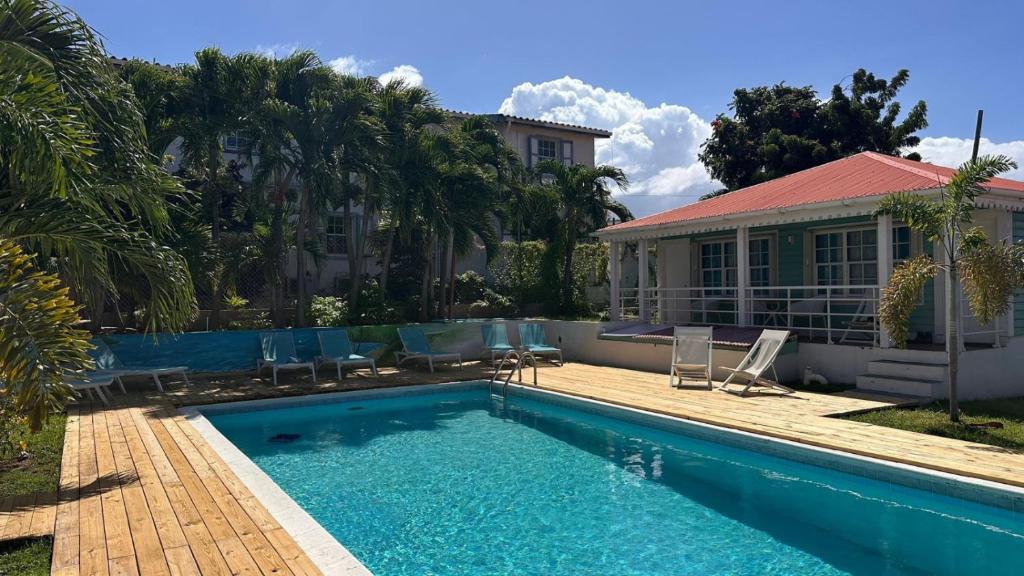 ein Swimmingpool vor einem Haus in der Unterkunft Talk of the Town Inn & Suites - St Eustatius in Oranjestad