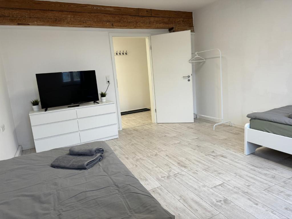 a bedroom with a flat screen tv on a dresser at Monteurzimmer Renix Heilbronn in Brackenheim
