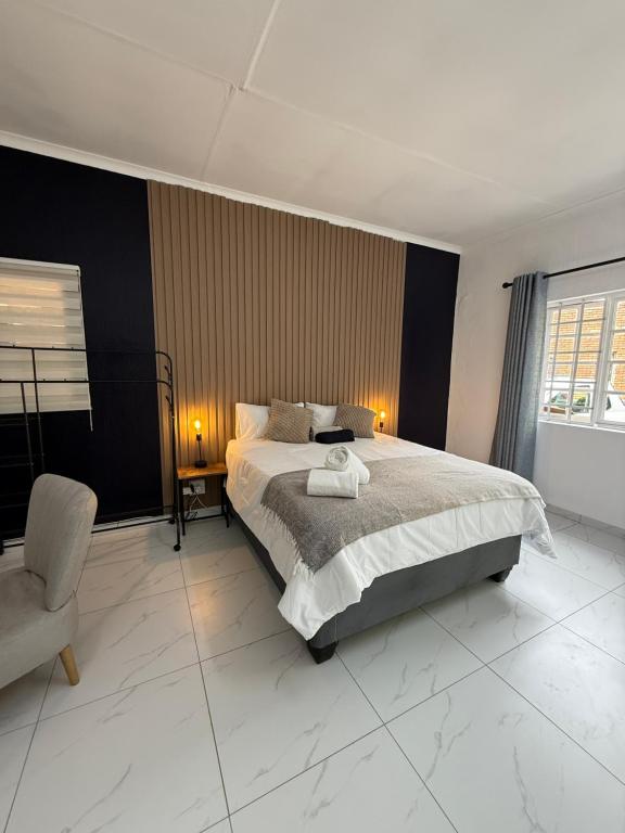 una camera da letto con un letto grande e una sedia di Tambo Touchdown Suites a Benoni