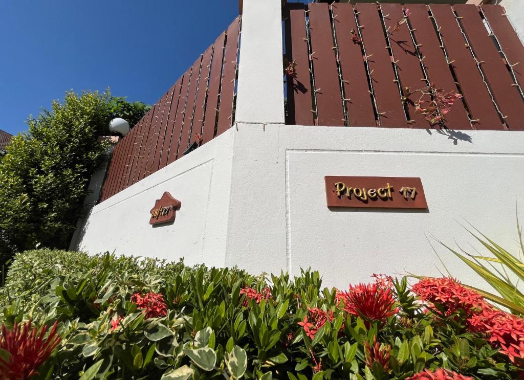 a white building with a red roof and some flowers at Project 17 B&B in Hua Hin