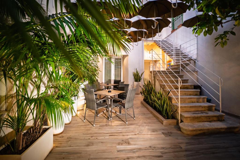 a room with a staircase and a table and chairs at Il cortile di Elen in Marsala