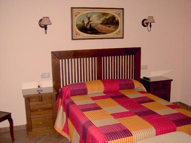 a bedroom with a bed with a colorful blanket and a dresser at Villa de La Yunta in La Yunta