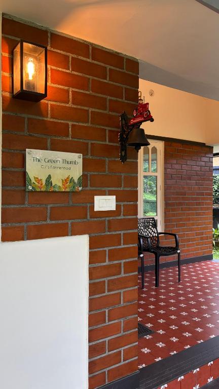 a brick wall with a bench next to a building at The Green Thumb Farm Stay in Mundakāyam