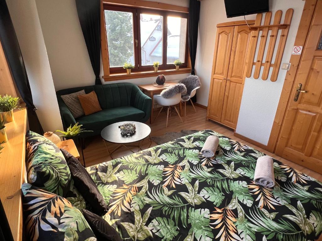 a living room with a bed and a couch at Czekoladowa Willa in Białka Tatrzanska