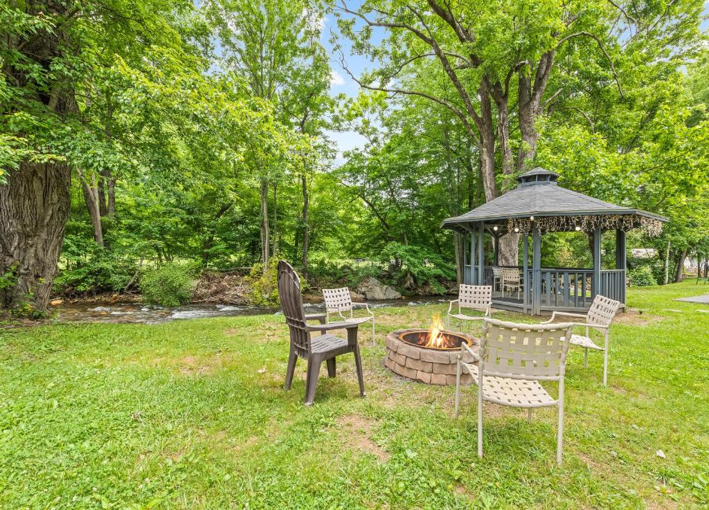 a gazebo with chairs and a table and a fire pit at The Valley Inn in Maggie Valley