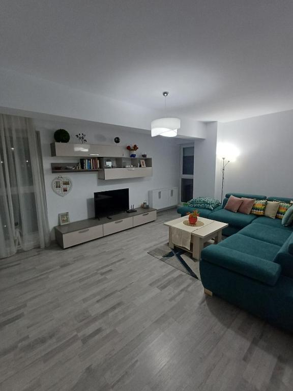 a living room with a blue couch and a tv at Favorite Apartmet in Braşov