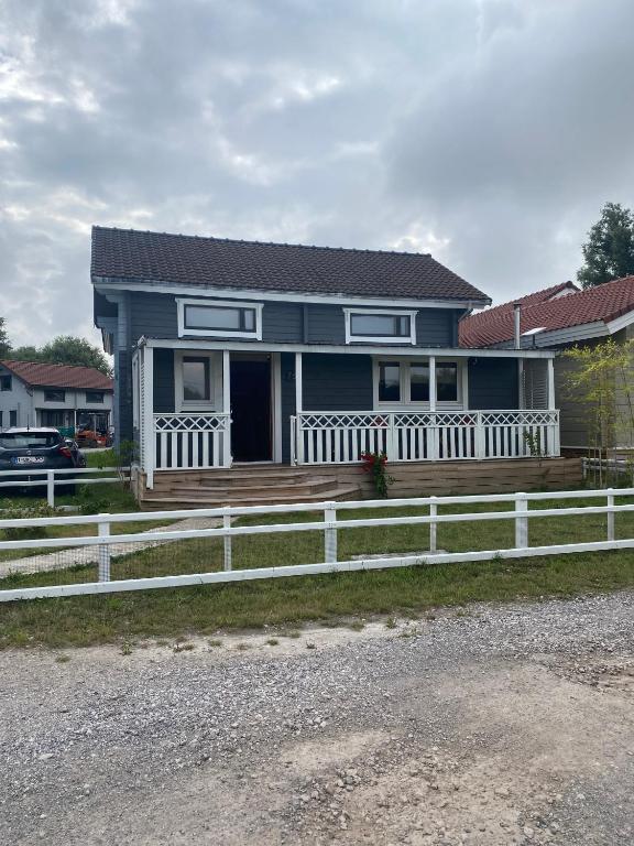 a blue house with a white fence in front of it at Le Havre de Bois in Bourbourg