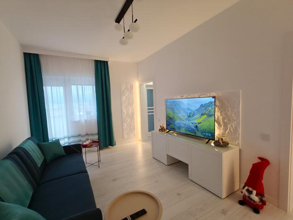 een woonkamer met een blauwe bank en een flatscreen-tv bij Home Ready in Sibiu