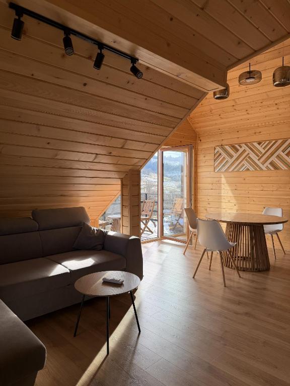 a living room with a couch and a table at Lemko Lodge in Novyy Kropivnik