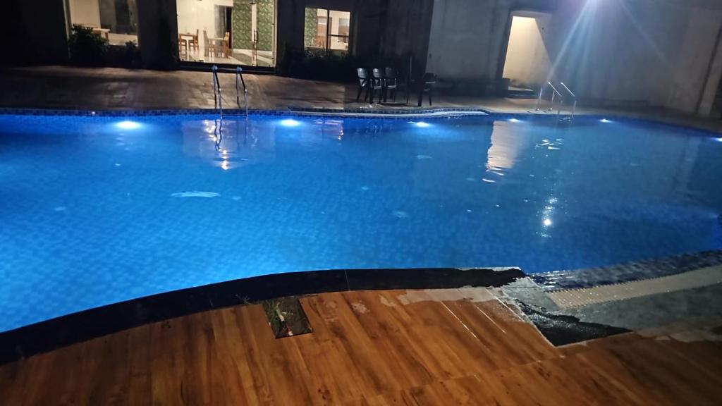 una grande piscina con acqua azzurra di Corbett Crown Resort a Ramnagar