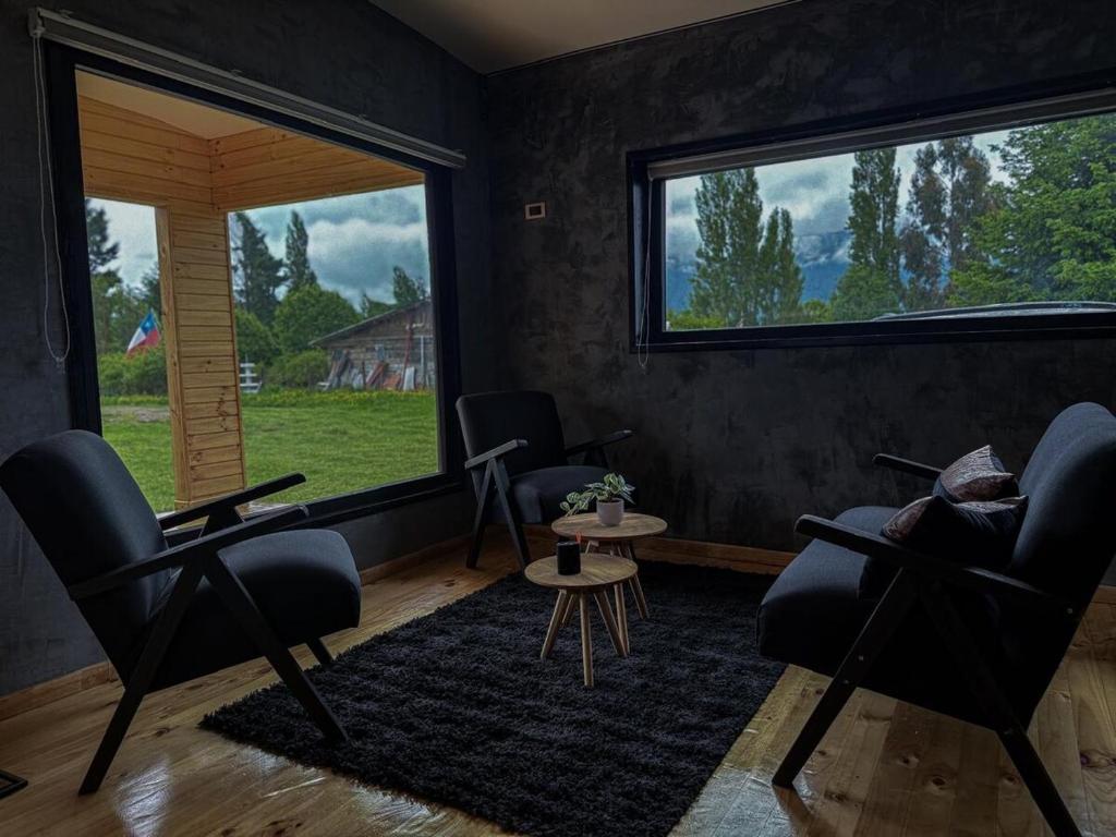 a living room with two chairs and a large window at Refugio Nauru in Puerto Dunn