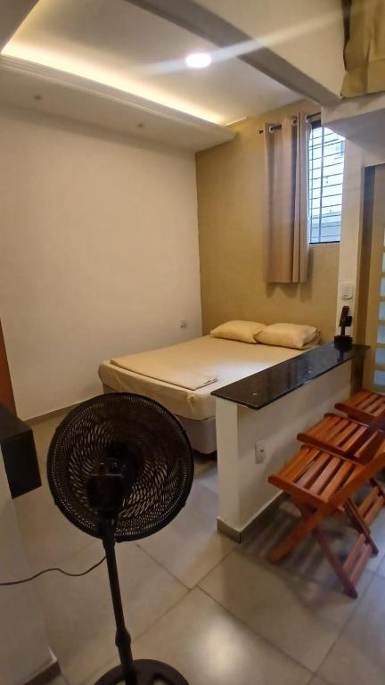 a room with a bed and a table and chairs at Loft Centro in Aparecida