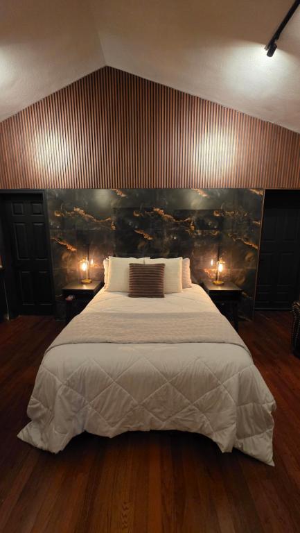 una camera da letto con un letto grande e due tavoli con luci di Luxury Suites Tokio a 100 mts del consulado a Manuel F. Martínez