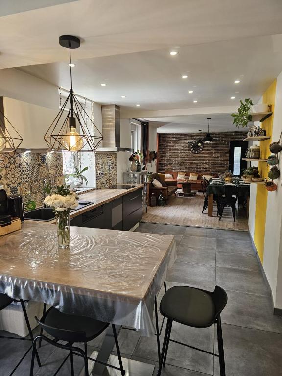 a kitchen and living room with a table and chairs at La Halte D'Aristide - Parking in Cravanche