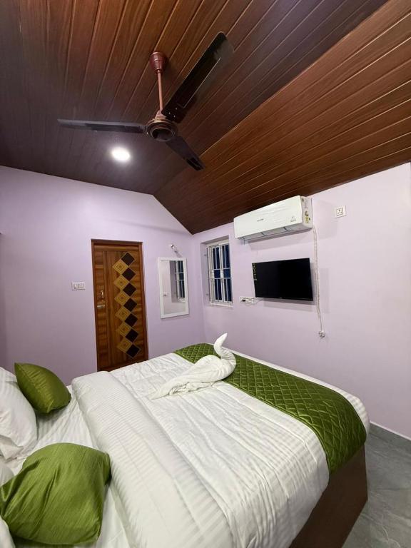 um quarto com uma cama grande com teto em le hut residency em Pondicherry
