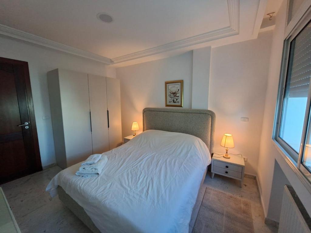 突尼斯Lac 2 Luxury apartment C的卧室里有一张白色的床和两盏灯