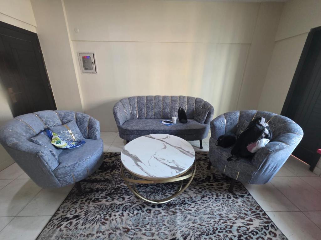 een woonkamer met twee stoelen en een tafel bij Star Residence in Karachi