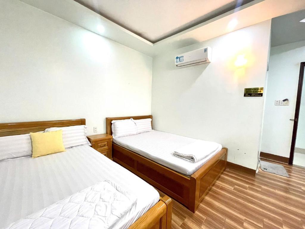 迪石Nhà Nghỉ Thành Đạt - Bến Tàu Phú Quốc的有两张床和一扇窗户的小房间