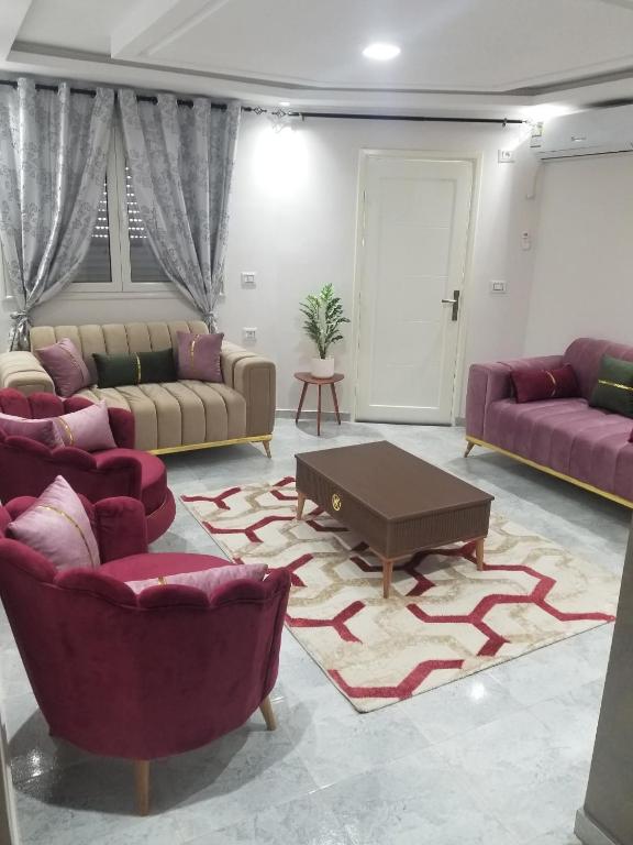 a living room with couches and a coffee table at Appartement Oasis Chenini Gabes in Shanīnī