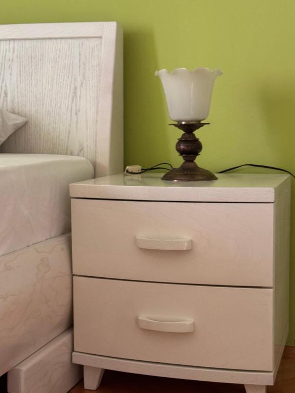 a white dresser with a lamp on top of it at KMB suite in Nikšić